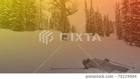 Composition of skier lying in snow in mountains with orange tint 78229984