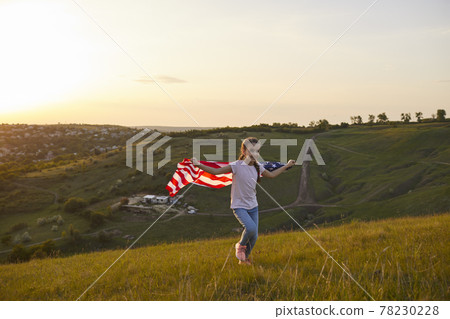 Girl with American flag running through the field at sunset in nature. Girl with American flag running through the field at sunset in nature. 78230228