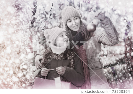 Smiling girl with woman are buying toys for X-mas tree Smiling girl with woman are buying toys for X-mas tree 78230364