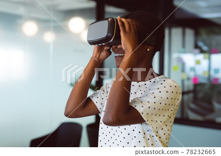 Smiling african american woman using vr headset at work Smiling african american woman using vr headset at work 78232665