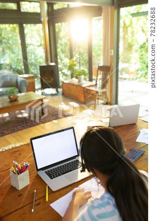 Asian girl using laptop with blank screen, writing, learning online Asian girl using laptop with blank screen, writing, learning online 78232688