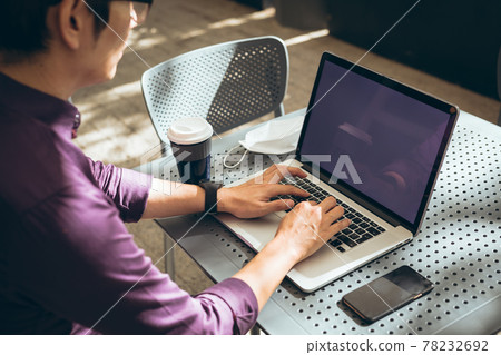 Asian businessman using laptop with blank screen sitting at table in cafe Asian businessman using laptop with blank screen sitting at table in cafe 78232692