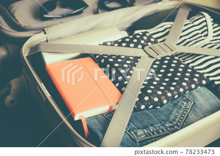 Open suitcase full of clothes isolated on black background Open suitcase full of clothes isolated on black background 78233473