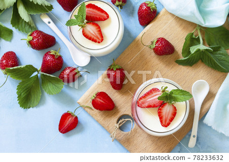 Mango Panna Cotta with jelly and mint strawberries, Italian dessert, home cooking. Top view flat lay background. Mango Panna Cotta with jelly and mint strawberries, Italian dessert, home cooking. Top view flat lay background. 78233632