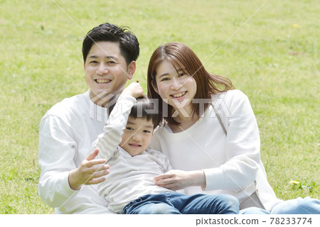 依偎在公園裡的年輕家庭 依偎在公園裡的年輕家庭 78233774