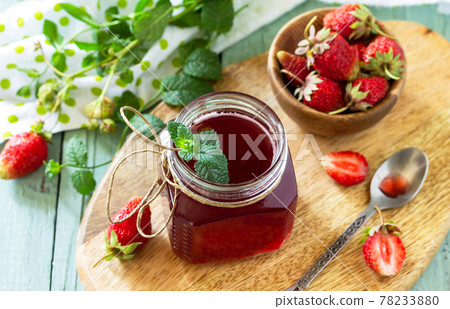 Strawberry berry syrup and fresh strawberry berries on a wooden table. Strawberry berry syrup and fresh strawberry berries on a wooden table. 78233880