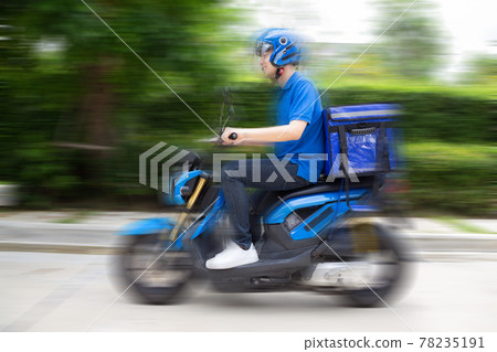 Delivery man wearing blue uniform riding motorcycle and delivery box. Motorbike delivering food express service concept 78235191