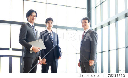 Three businessmen standing side by side 78235210