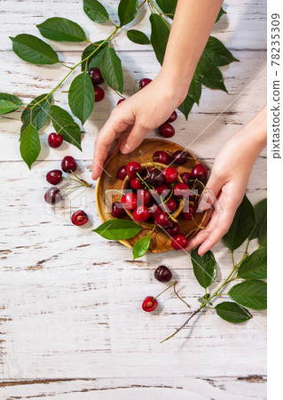 Ripe juicy berry cherry in a bowl on a kitchen rustic table. Top view flat lay background. 78235309