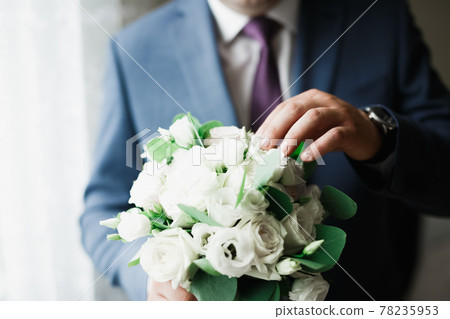 Beautiful man, groom holding big and beautiful wedding bouquet with flowers 78235953