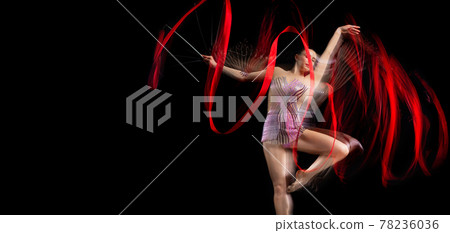 One femalel rhythmic gymnast in motion and action isolated in mixed light on dark background. Flyer 78236036