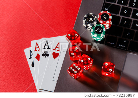 Online poker casino theme. Gambling chips and playing cards on a red background Online poker casino theme. Gambling chips and playing cards on a red background 78236997