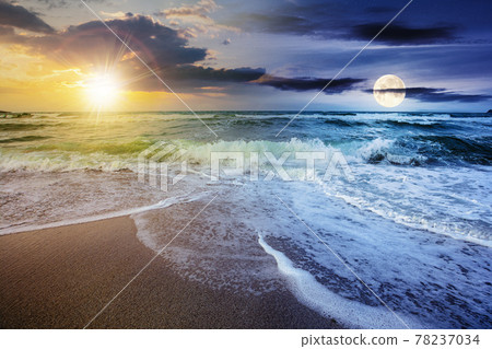 day and night time change concept above sea tide on a cloudy twilight. green waves crashing golden sandy beach with sun and moon above the horizon. storm weather approaching. summer holiday concept 78237034