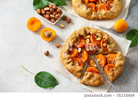 Healthy pastries made from rye flour, dessert diet food. Galette with apricots and nuts on a light stone table. Copy space. Healthy pastries made from rye flour, dessert diet food. Galette with apricots and nuts on a light stone table. Copy space. 78238984