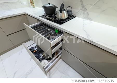 Open drawer with cutlery at modern white woden kitchen in classic style 78240949