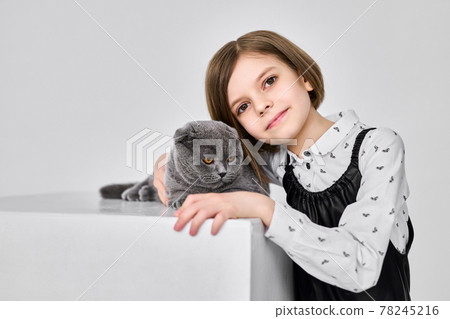 Caucasian little girl holds her cat in the arms Caucasian little girl holds her cat in the arms 78245216