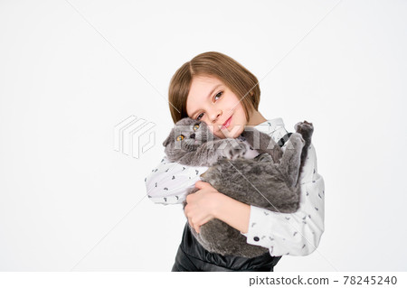 Caucasian little girl holds her cat in the arms 78245240
