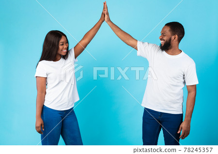 Portrait of happy black couple celebrating win giving high five Portrait of happy black couple celebrating win giving high five 78245357