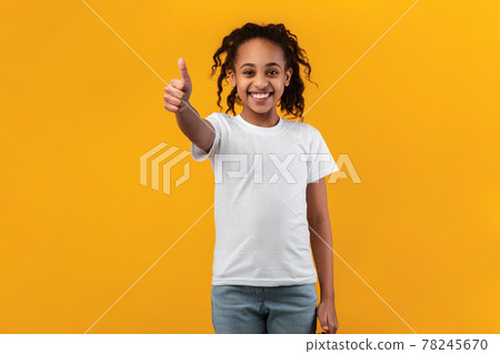 Happy black girl gesturing thumbs up and smiling Happy black girl gesturing thumbs up and smiling 78245670
