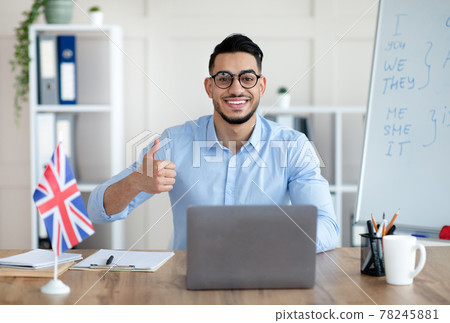 Young Arab tutor conducting online English lesson, showing thumb up, teaching foreign language from home Young Arab tutor conducting online English lesson, showing thumb up, teaching foreign language from home 78245881
