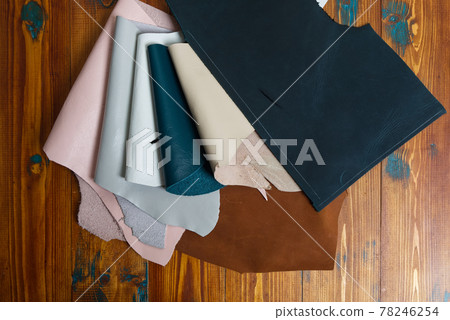 Various Kind and Color Genuine Leather Scraps on the Wood Table 78246254