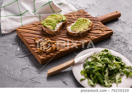 Avocado sandwich on dark rye bread made with fresh sliced avocados from above. Breakfast concept. Avocado sandwich on dark rye bread made with fresh sliced avocados from above. Breakfast concept. 78250320