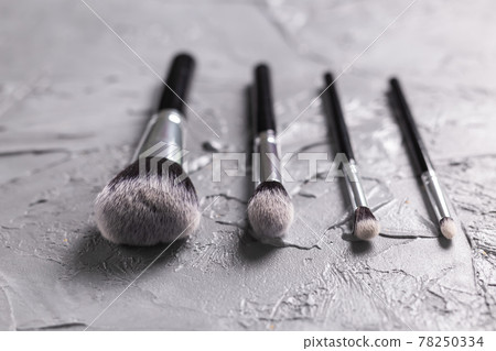 Top view of make-up brushes on grey background Top view of make-up brushes on grey background 78250334