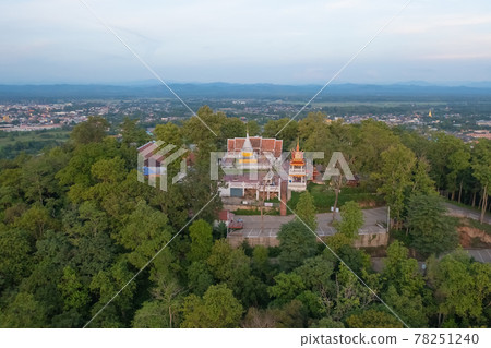 Aerial view of golden buddha pagoda stupa. Wat Phrathat Khao Noi Temple Park, Nan, Thailand with green mountain hills and forest trees. Thai buddhist temple architecture. Tourist attraction. 78251240