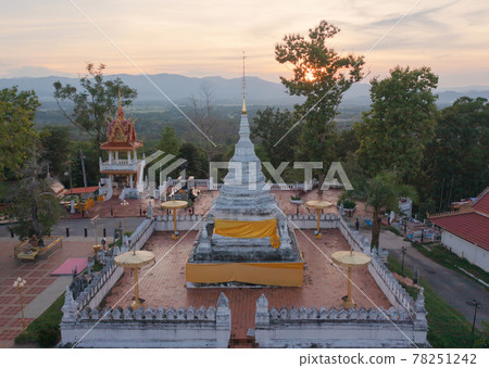 Aerial view of golden buddha pagoda stupa. Wat Phrathat Khao Noi Temple Park, Nan, Thailand with green mountain hills and forest trees. Thai buddhist temple architecture. Tourist attraction. Aerial view of golden buddha pagoda stupa. Wat Phrathat Khao Noi Temple Park, Nan, Thailand with green mountain hills and forest trees. Thai buddhist temple architecture. Tourist attraction. 78251242