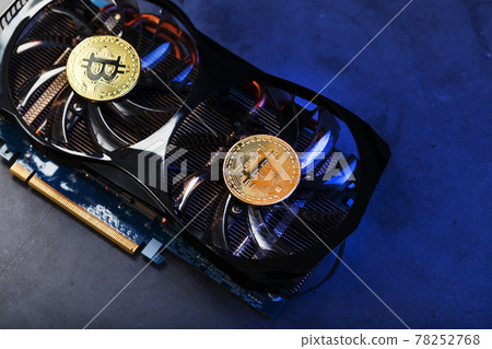 Video card with a gold coin Bitcoin on the cooler close-up. Video card with a gold coin Bitcoin on the cooler close-up. 78252768