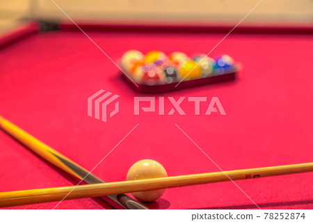 Cue sticks and billiard balls on a red pool table Cue sticks and billiard balls on a red pool table 78252874