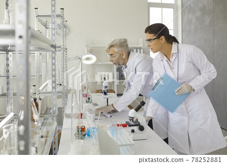 Male and female scientist analyzing results on computer screen at laboratory Male and female scientist analyzing results on computer screen at laboratory 78252881
