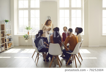People participating in group therapy for social skill training in bright office People participating in group therapy for social skill training in bright office 78252884