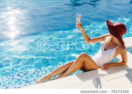 woman relax in swimming pool and drinks champagne woman relax in swimming pool and drinks champagne 78253308
