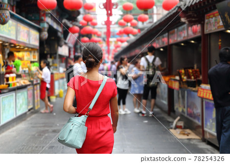 Woman tourist walking in chinatown on china travel. Asian girl on Wangfujing food street during Asia summer vacation. Traditional Beijing snacks being sold at chinese chinatown outdoor market 78254326