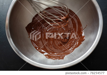 Melting chocolate in pot on dark 78254577
