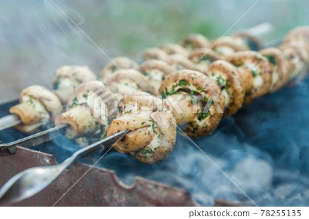 Grilled mushrooms on skewers cooked in a brazier, close-up, retr Grilled mushrooms on skewers cooked in a brazier, close-up, retr 78255135