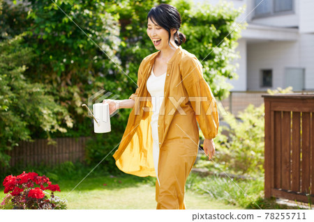 Middle woman watering flowers in the garden 78255711