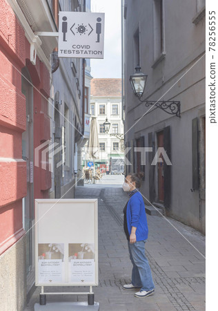 Woman wearing a medical mask in front of a Covid Test Center for Antigen or PCR Tests during Coronavirus pandemic in Graz, Austria Woman wearing a medical mask in front of a Covid Test Center for Antigen or PCR Tests during Coronavirus pandemic in Graz, Austria 78256555