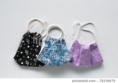 Handmade cloth mask, beautiful pattern placed on a white background. A mask concept that helps prevent the spread of the coronavirus (COVID-19). Closeup, Copy space on top for design or text 78256679