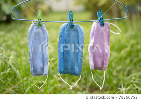 Handmade cloth mask, beautifully colorful, hang in the sun. Mask concept that helps prevent the spread of a coronavirus (COVID-19). Closeup, copy space on right for design or text, Blurred background 78256752