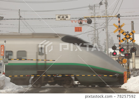 Shinkansen passing through a railroad crossing 78257592