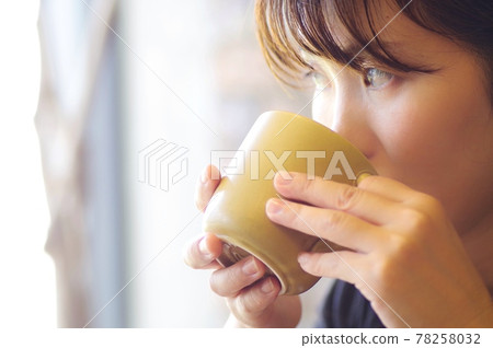 一個女人喝著一大杯 78258032