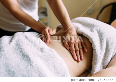 The masseur gives a massage to the female belly at the spa. The masseur gives a massage to the female belly at the spa. 78262272