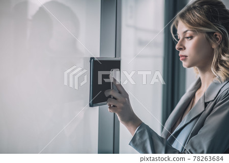 Woman touching smartphone to intercom at office Woman touching smartphone to intercom at office 78263684