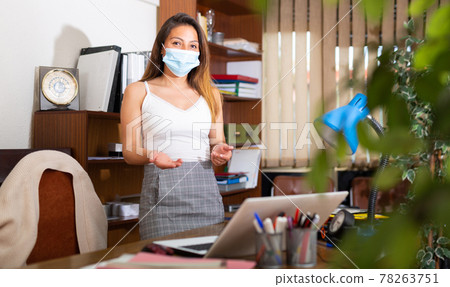Business woman in protective mask inviting to office Business woman in protective mask inviting to office 78263751