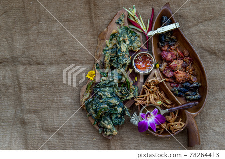 Crispy Flowers, Crispy Herbs and Crispy Vegetables served with Sweet sauce in a Wooden tray. Crispy Flowers, Crispy Herbs and Crispy Vegetables served with Sweet sauce in a Wooden tray. 78264413
