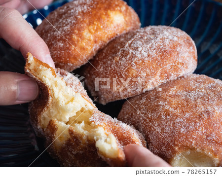 A close-up of a donut named Malasada. Sweet sweets made by sprinkling plenty of sugar on fried bread. A close-up of a donut named Malasada. Sweet sweets made by sprinkling plenty of sugar on fried bread. 78265157