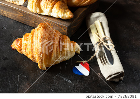 Croissants and cutlery on a dark table 78268081