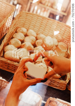 Women hands in a shop window, behind which are chocolate muffins. Love for sweets and pastries. Muffins in the cafe. Vertical photo Women hands in a shop window, behind which are chocolate muffins. Love for sweets and pastries. Muffins in the cafe. Vertical photo 78270496